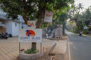 a sign on a tree on the side of a street at Goan Bliss Alaya Stays by ELIVAAS in Varca