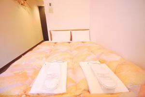 a bedroom with a bed with two whiteboards on it at Sakura Hotel Ikebukuro in Tokyo