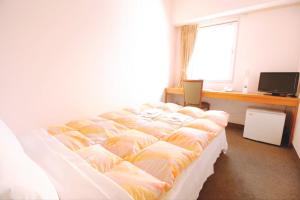a bedroom with a bed and a desk and a window at Sakura Hotel Ikebukuro in Tokyo