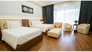 a hotel room with two beds and a couch at Tara Hotel & Spa in Hanoi