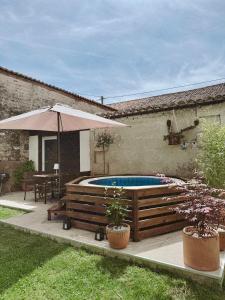 a swimming pool with an umbrella in a yard at Escapade bohème in Bergerac