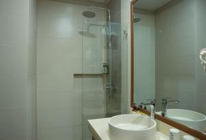 a bathroom with a sink and a glass shower at Acuaverde Beach Resort in San Juan +27 photos