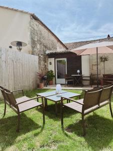 a table and two chairs and an umbrella in a yard at Escapade bohème in Bergerac