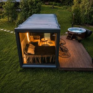 a tiny house with a fireplace in the grass at Reborn Cabins in Pabaži
