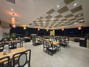 a restaurant with wooden tables and chairs in a room at Hotel Santoor - Geeta Bhawan Square in Indore