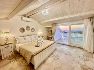 a bedroom with a large bed and a large window at Godano Rooms in Drapia