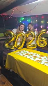 two women standing next to a table with gold balloons at Vacaciones Aregua (Casa Pablo) in Areguá +41 photos