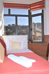 um quarto com uma cama e uma janela grande em Hotel The First em Gjirokastër mais 37 fotografias