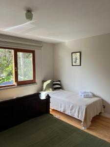 a bedroom with a bed and a window at Termo Cottage in Lagoa