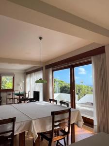 a dining room with a table and a large window at Termo Cottage in Lagoa