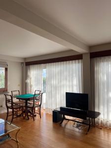 a living room with a table and a piano at Termo Cottage in Lagoa