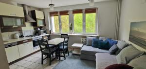 a living room with a couch and a table and a kitchen at Apartament Kolberga w Sopocie in Sopot