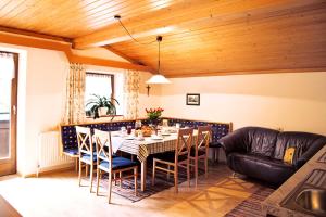 ein Esszimmer mit einem Tisch, Stühlen und einem Sofa in der Unterkunft Ferienhaus Nationalpark in Neukirchen am Großvenediger