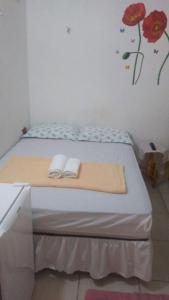 a bed with two towels on it in a room at Hospedaria Praia e Sol in Fortaleza