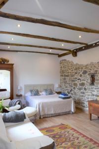 a bedroom with two beds and a stone wall at Anikuenea in Zaláin