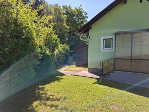 a backyard of a house with a grass yard at Haus Luisi in Hitzendorf +6 photos