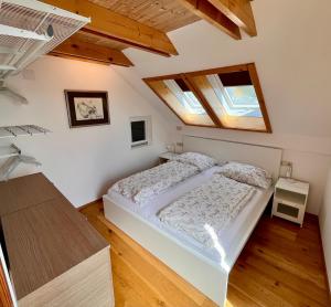 a bedroom with a white bed and a wooden floor at Free Living Freistadt in Freistadt
