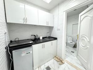 a white kitchen with a sink and a toilet at Velmora Villas room 14 in Abu Dhabi