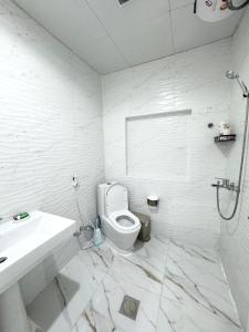 a white bathroom with a toilet and a sink at Velmora Villas room 14 in Abu Dhabi