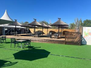 a patio with tables and chairs and umbrellas at Mobilehome in Vias