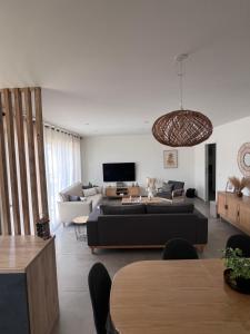 a living room with a couch and a table at NeseHome, Maison à proximité du Futuroscope in Montamisé