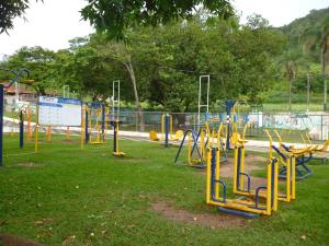 a playground with yellow and blue equipment in a park at Flats Cavalinho Branco 405 ou 603 in Águas de Lindóia