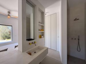 a white bathroom with a sink and a mirror at ARETI Horizon in Kástron +30 photos