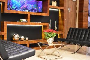 a living room with two black leather chairs and a table at Hotel Santa Monica in Mikołajki