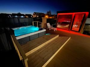 a hot tub on top of a deck at night at Aura Baltic in Rewal