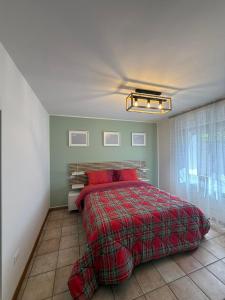 a bedroom with a bed with a red comforter at Villa Augusta in Auronzo di Cadore