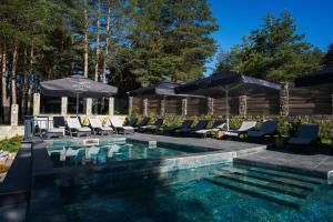 a swimming pool with chairs and umbrellas at Brentas Spa Resort in Tsigov Chark +69 photos