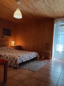 a bedroom with a bed and a table and a window at La Casa Antica in Pont-Saint-Martin