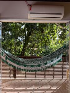 a hammock hanging from the back of a building at Pituba Vile - Apartamento Jardim in Itacaré