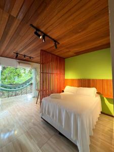 a bedroom with a bed and a green wall at Pituba Vile - Apartamento Jardim in Itacaré
