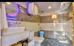 a bathroom with a white toilet and a sink at Regal Retreat in Jari