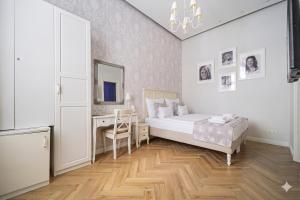 a bedroom with a bed and a desk with a mirror at Serenity Boutique Budapest in Budapest