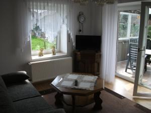 uma sala de estar com um sofá, uma mesa e uma televisão em Ferienwohnung Am Bach em Rees