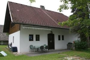 ein weißes Haus mit einem Tisch und Stühlen in der Unterkunft Haus Hubertus in Radnig