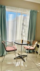 a table and two chairs in front of a window at Hidden Bliss Guesthouse in East London