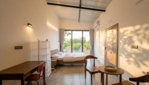 a room with a bed and a desk and a table at Amrutiya Farm in Bhuj