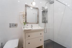 a white bathroom with a sink and a mirror at Serenity Boutique Budapest in Budapest