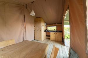 a tent with a wooden table in a room at Camping de Haas in Wolphaartsdijk