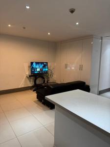a living room with a couch and a television at island payless private room in Nadi