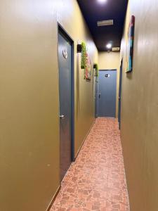 a hallway with doors and a tile floor at Ghazrins Garuda Hotel in Johor Bahru +22 photos