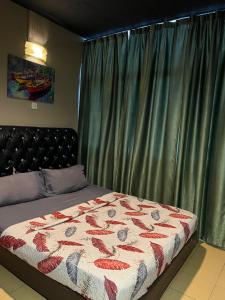 a bedroom with a bed with a quilt on it at Ghazrins Garuda Hotel in Johor Bahru