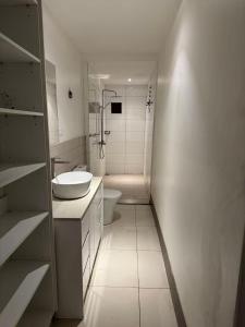 a white bathroom with a toilet and a sink at island payless private room in Nadi