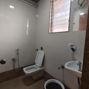a bathroom with a toilet and a sink at Ruby Lodging And Boarding in Mangrul