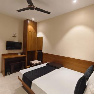 a bedroom with a bed and a flat screen tv at Ruby Lodging And Boarding in Mangrul