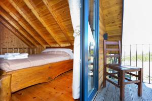 a bedroom with a bed and a chair on a porch at Sinja Park Villas in Sinjë
