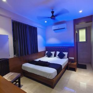 a bedroom with a large bed with a blue ceiling at Ruby Lodging And Boarding in Mangrul